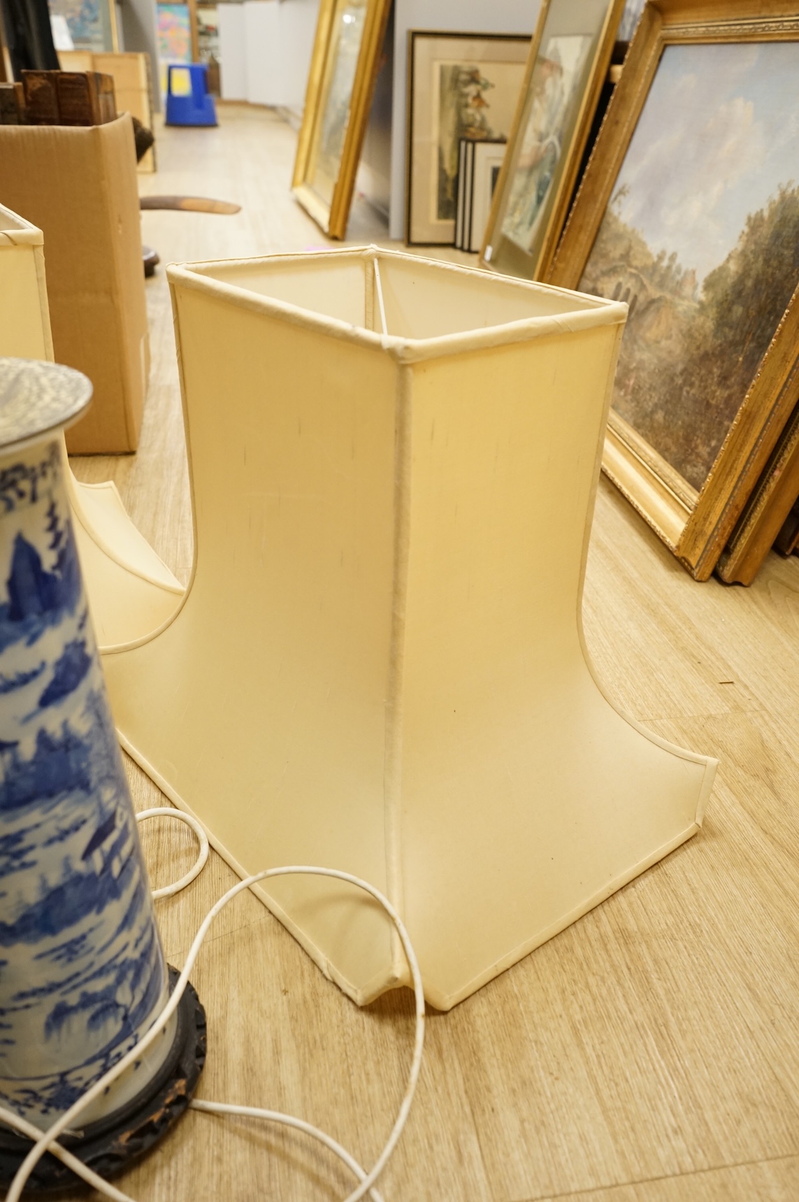 A pair of tall Chinese blue and white ‘landscape’ sleeve vases, c.1900, drilled and mounted as lamps with shades, 39cm high excluding the fitting